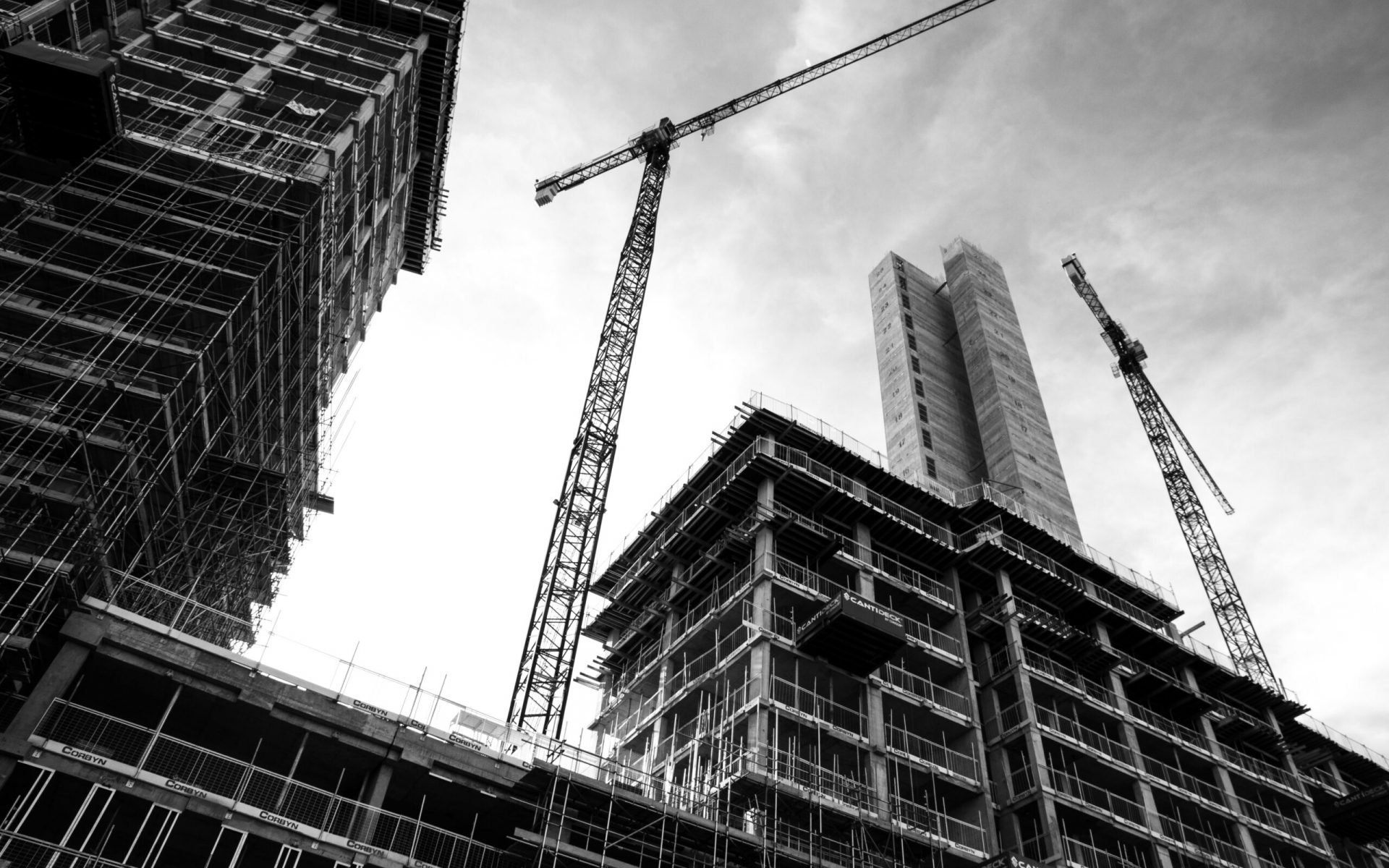 grayscale photo of crane in front of building