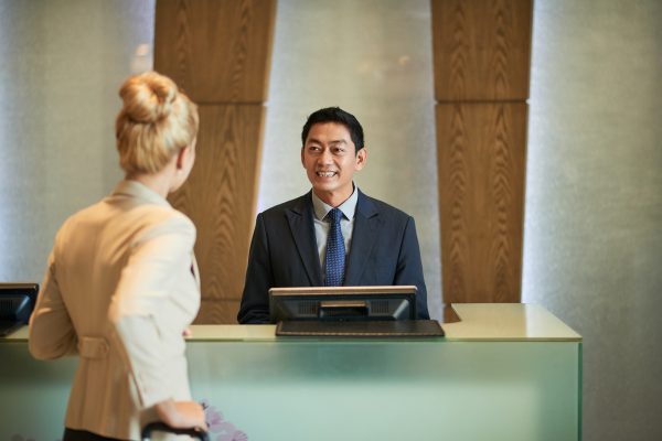 Business lady talking to receptionist of hotel
