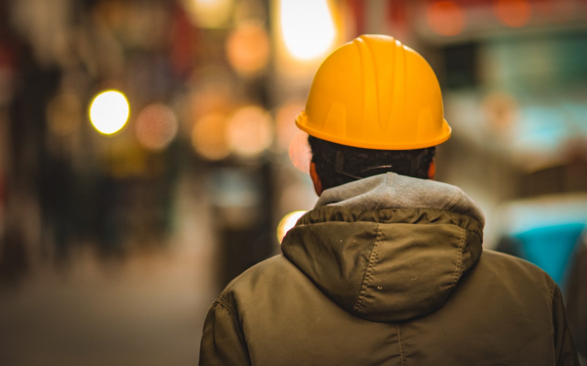 person in yellow hard hat and brown jacket